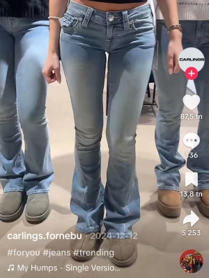 Ljusblå bootcut jeans från truereligion - Säljer ett par ljusblå bootcut jeans från religion med klassisk femficksmodell och låg midja. Jeansen har slitna detaljer på fickorna och är tillverkade i stretchig denim för en bekväm passform. Perfekta för en trendig och avslappnad look.