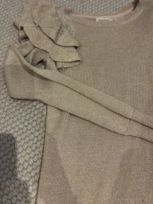 Glitter/guld klänning barn - En glitter/guldig klänning för flicka 8-9 år från MarMar. Stretchig så passar lite större storlek också. Nypris 600 kr. Perfekt för julafton och nyår eller liknande. Säljer då den är för liten. Bra är att glittret ej försvinner i tvätten eller så. Söta puffiga ärmar och perfekt längd. Alltid glittrigast i rummet ;)