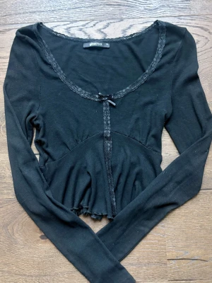 Svart långärmad bolerotopp med spets - Svart långärmad bolerotopp från Gina Tricot med spetsdetaljer längs ringningen och framtill. 