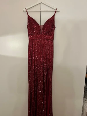 Röd glittrig balklänning - Storlek 36/M, detaljerad rygg, slit på framsidan och använd en gång. Köpt för 2500kr men säljer för 2000kr, pris kan diskuteras annars💕