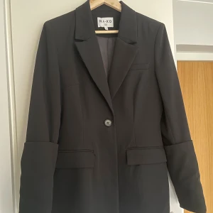 Blazer - Svart blazer med insydd midja och uppvikt ärm.