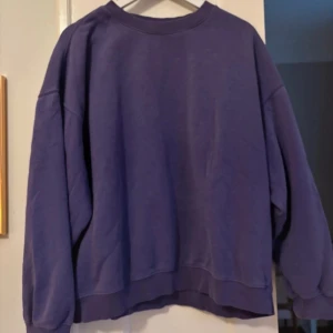 Oversized lila sweatshirt från Weekday - Säljer en oversized sweatshirt från Weekday i en snygg lila färg. Tröjan har rund hals, långa ärmar och ribbade muddar vid hals, ärmslut och nederkant. Mjuk insida i bomull och polyesterblandning, perfekt för chill dagar.