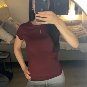 Vinröd t-shirt - Snygg vinröd t-shirt med rund hals och korta ärmar. Modellen är figurnära och passar perfekt till jeans eller mjukisbyxor. Materialet är mjukt och skönt bomull, vilket gör den superbekväm att ha på sig hela dagen. Obs!!! Storlek medium men passar även mig som har xs🥰