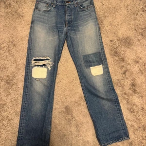 Nudie Jeans Original Patchwork  - Säljer dessa sjukt feta One of a Kind Nudies. Modellen är loose Leif som är en rak/vid modell. Finns endast ett ental av dessa byxor och dessa är i väldigt bra skick. Storleken är W29 L32 och dessa är från 2015 som ses på bild 3. Väldigt skönt material som kanppt känns använt. Mått: Midja: 38-38,5 cm. Ytterbenslängd: 105 cm. Benöppning: 20 cm.                                 Om det finns frågor eller prisförslag är det bara att skriva.