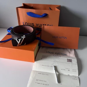 Louis Vuitton bälte brunt med silver logo - Helt ny Louis Vuitton bälte med brunt skärp och lv märken, silver logo. Ingår allt som du ser på bilden, box, kartong, kvitto och järn sak för att göra hål