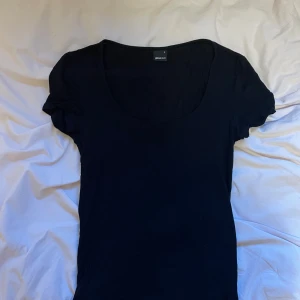 Svart topp från Gina Tricot - Basic svart topp från Gina Tricot med rundad, djup ringning och korta ärmar🤗 