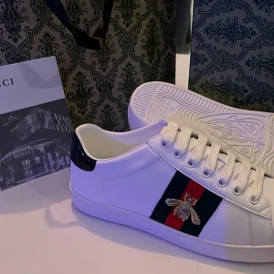  Ace sneaker with bee - Gucci Ace skor. Bra skick. Original storlek 42 men passar någon som har 43 (sitter ganska tight) Passar 42-42.5 bekvämt. allt på bilden kommer med. bara skriv vid funderingar. skorna är helt nya. Kan sänka priset vid snabb affär 👌