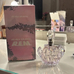 Ariana Grande R.E.M. parfym 50ml - Snygg parfym från Ariana Grande, R.E.M. i en unik kristallin flaska. Volymen är 50 ml, perfekt storlek för att ta med i väskan. En populär doft bland unga, inspirerad av Ariana Grandes stil.