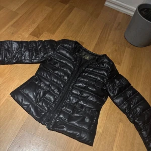 Svart dunjacka från Yes!Miss - Snygg svart dunjacka från Yes!Miss med quiltad design och dragkedja framtill. Jackan har långa ärmar och praktiska fickor. Perfekt för kyligare dagar, jackan har slutat och säljas och är numera svår att få tag på. Pris kan diskuteras:)