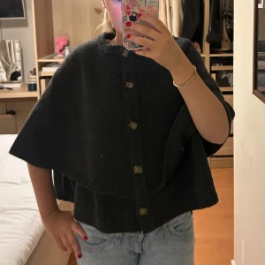 Poncho  - Säljer en mörkgrå, stickad poncho ifrån Zara. Köpt för 560 kr. Perfekt att slänga över en tröja för extra värme. Typ aldrig använd. Pris går att diskutera. 