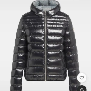 Svart glansig pufferjacka från Colmar - Snygg svart pufferjacka från Colmar i glans. Jackan har huva, dragkedja framtill och quiltad design. Perfekt för kalla dagar 💕