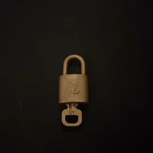 Louis Vuitton lås  - Ett Louis Vuitton Paris lås som brukar komma med LV väskorna! Men brukar användas som berlock till tex halsband 