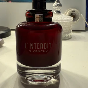 Givenchy L'Interdit Rouge 50ml - Givenchy L’Interdit Rouge – 50 ml EdP Originalparfym, köpt i butik. Endast använd ett fåtal gånger – ca 90 % kvar (se bild). Batchkod: 4C01 (mars 2024) – syns på bild för äkthetsverifiering. Saknar lock, men flaskan och sprayen fungerar perfekt.  💰 Nypris ca 1 300 kr – jag säljer för 600 kr 