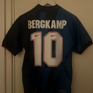 Bergkamp #10 Arsenal - Arsenal tröja från 90 talet med Favoriten Bergkamp på ryggen, tröjan är Storlek XL i barnstorlek vilket gör att den är mer som en Small i ”vanlig” storlek, passar även dig som gillar lite ”tajtare” tröjor och har vanligtvis M. Priset är ej hugget i sten