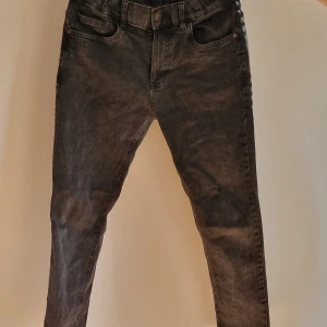 Svarta skinny jeans med tvättad look - Snygga svarta jeans med tvättad finish och klassisk femficksdesign. Modellen är skinny och har normal midja. Perfekta för dig som gillar en smal siluett och vill ha ett par stilrena jeans till din garderob.
