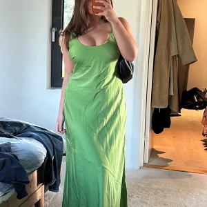 Grön långklänning i satin - Grön satin klänning från asos, använd 1 gång men har en del fläckar. Har inte testat att tvätta så kan nog gå bort. Nypris 859