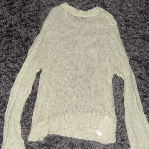 Ljusbeige/grön  stickad tröja Gina Tricot - Säljer en tunn och mjuk stickad tröja från Gina Tricot i ljusbeige färg. Tröjan har långärmad passform, rund hals och är lätt transparent med ett luftigt stickat mönster. Perfekt att styla med jeans eller kjol för en chill look.