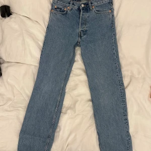 Weekday Klean Regular Straight Jeans - Säljer ett par klassiska blå Weekday Klean Regular Straight Jeans med raka ben och normal passform. Jeansen är tillverkade i bomull med en snygg ljus tvätt. Perfekta för en clean och stilren look.