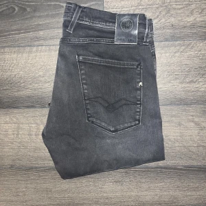 Replay Anbass jeans  - Svarta Replay Anbass jeans i slim fit med klassisk femficksdesign och snygga detaljer på bakfickorna. Jeansen har en mörk tvätt och är tillverkade i stretchig bomullsblandning. Midja 42cm, längd 105cm. JAG SKICKAR EJ FLER BILDER NÄR JAG BÄR JEANSEN! för storleksguide hänvisar jag till måtten och för bättre inblick i passformen rekommenderar jag att googla på modellnamnet :) s3