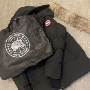 Jacka från Canada Goose - Svart Canada goose jacka. Helt ny aldrig använd, säljer den på grund av inte är min stil. Riktigt fint passform perfekt nu inför kalla dagar.