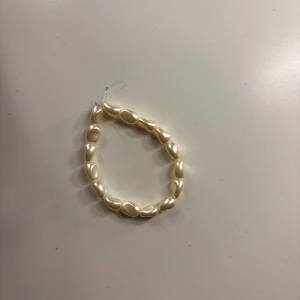 Pärlarmband med oregelbundna pärlor - Ett stilrent och exklusivt armband med ovala, oregelbundna pärlor i vit nyans. Pärlorna har en fin glans och sitter på en elastisk tråd som gör det enkelt att ta på och av. 💖