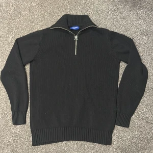 Svart stickad half zip från Jack & Jones - Svart stickad tröja från Jack & Jones med half zip och hög krage. Tröjan är inprincip aldrig använd. Storlek Small: Nypris ca 700 kr