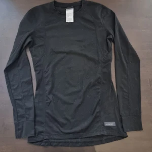 Svart underställ Everest - Svart underställfrån Everest med rund hals och diskret logga vid nederkanten. Top och byxor är i storlek s