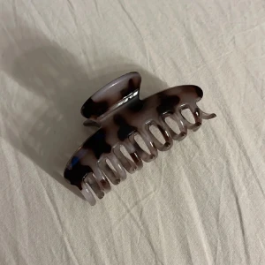 Två hårklämmor i marmor och sköldpaddsmönster - Säljer två trendiga hårklämmor – en i vit marmorlook och en i klassiskt brunt sköldpaddsmönster. Perfekta för att snabbt fixa frisyren och ge en snygg detalj till håret. Båda klämmorna är stora och håller håret på plats hela dagen.