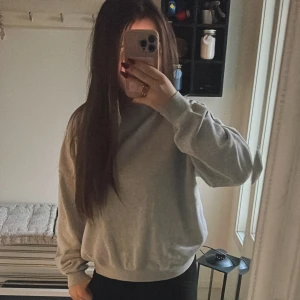 Grå sweatshirt från 157, storlek S - En basic grå sweatshirt från 157 i storlek S. Tröjan har rund halsringning, ribbade muddar vid ärmslut och nederkant samt en loose passform. Perfekt för chill dagar och enkel att matcha med allt. Materialet är mjukt och skönt, troligtvis bomullsmix.