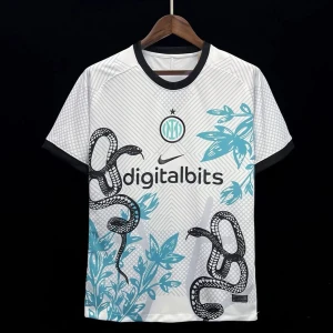 Inter Milan vit bortatröja Nike - Inter Milans vita bortatröja från Nike med svart krage och ärmslut. Tröjan har unikt ormmotiv och blåa bladmönster, samt klubbmärke och sponsortryck på bröstet. Perfekt för dig som vill sticka ut på läktaren eller i stan.