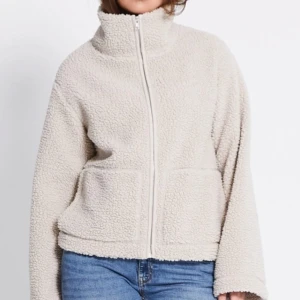  teddyjacka med dragkedja - Mysig beige teddyjacka med hög krage och hel dragkedja framtill. Säljer jackan i VIT inte begie!💕