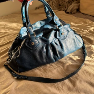 Blå Marc Jacobs väska 💗 - Säljer min jättefina och rymliga Marc Jacobs väska.💗 Ganska mycket slitage, därav priset. Saknar också taggen. 