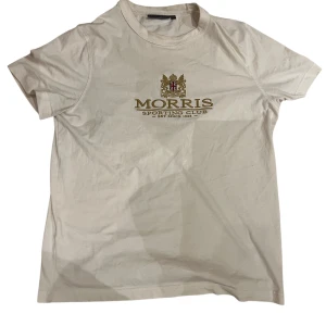 Vit t-shirt från Morris Sporting Club - Snygg vit t-shirt från Morris Sporting Club med tryck och broderad logga framtill. Storlek S, hör av er vid intresse!