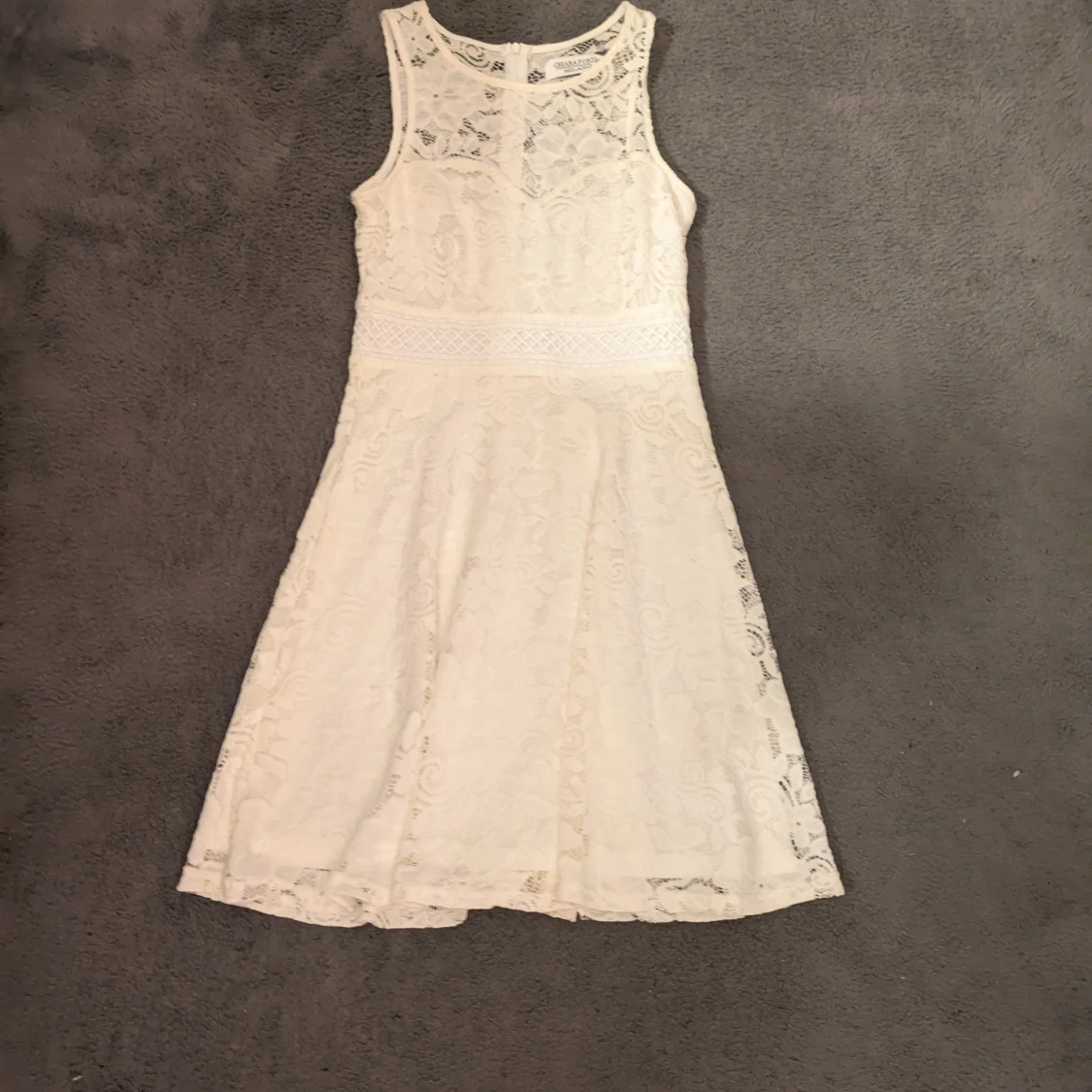 Vit spetsklänning med ärmlös design