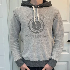Saint Laurent hoodie  - Säljer nu denna sjukt snygga och unika tröjan från Saint Laurent, den är i väldigt fint skick och har även äkthetsbevis från Vestiaire! 