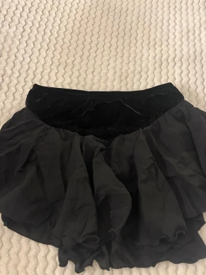 Svart konståkningskjol från Jerry's - Svart konståkningskjol från Jerry's med volang.