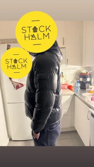 Svart pufferjacka Brave Soul M - Svart pufferjacka från Brave Soul i storlek M. Jackan har huva, dragkedja framtill och ficka med dragkedja på ärmen. Den är quiltad och har en loose passform som ger en chill vibe. Perfekt för kalla dagar när du vill hålla dig varm och se fresh ut. Pris går att diskutera 