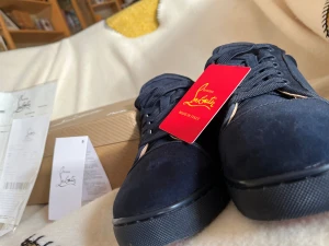 Mörkblå sneakers från Christian Louboutin - KAN PRATA OM PRISET. Snygga mörkblå sneakers från Christian Louboutin med autenticitetsbevis. Skorna har rund tå, platt sula och är tillverkade i mocka och textil. Klassisk snörning och diskret design med exklusiv känsla. Perfekta för dig som gillar lyxiga detaljer och stilren look.
