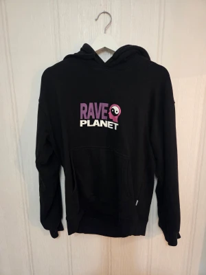 Valient hoodie med tryck - Svart hoodie från Valient med stort grafiskt tryck i lila och vitt både fram och bak. Tröjan har huva, magficka och långa ärmar. Stl S