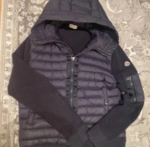 Mörkblå Moncler pufferjacka med huva - Snygg mörkblå pufferjacka från Moncler med stickade ärmar och huva. Kan sänka priset vid snabb affär