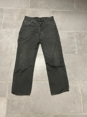Levi's 451 gråa jeans W29 L34 - Svarta Levi's 451 jeans med klassisk femficksdesign och raka ben. Jeansen har en snygg läderpatch bak i midjan och är tillverkade i robust bomullsmaterial. Passar dig som gillar en enkel och clean look med lite vintage-vibe. Hör gärna av er vid frågor! (;