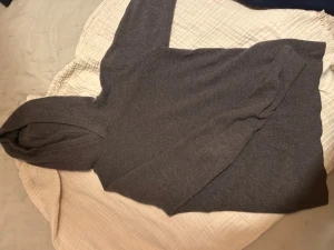 Mörkgrå hoodie i merinoull från Vailent - Snygg mörkgrå hoodie från Vailent i mjuk merinoull. Tröjan har huva och långa ärmar, perfekt för dig som gillar stilrena och bekväma plagg. Passformen är normal och materialet känns lyxigt mot huden. En enkel men riktigt fräsch hoodie för din garderob.