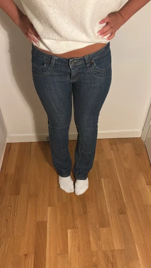 Mörkblå lågmidjade jeans med fickor 🤍 - Snygga blå jeans med låg midja och raka ben. Jeansen har dekorativa sömmar och en broderad detalj på bakfickan. Midjemått: 41cm & innebenslängd: 74cm. Skriv vid några som helst funderingar 🫶🏻