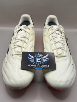 Adidas Copa pure 2 Elite FG  - Säljer ett par Adidas Copa fotbollsskor i vitt skinn med svarta detaljer och en cool röd/orange sula. Skorna har snörning och rund tå, perfekt för dig som vill sticka ut på planen. Klassisk Copa-design med modern touch och bekväm passform.