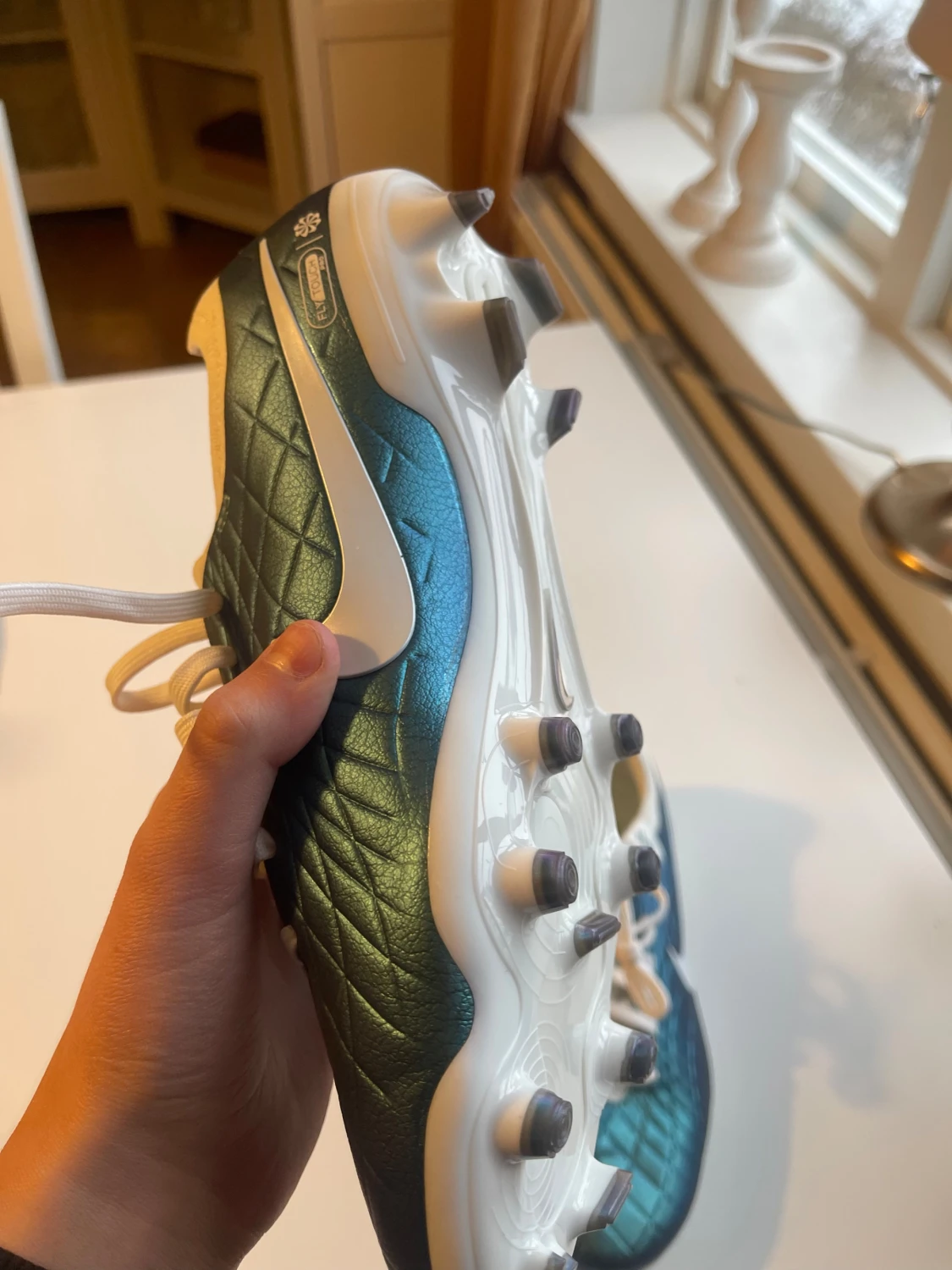 Detta är en fotbollssko av modellen Nike Tiempo Legend 10 Elite FG i en blå/grön iriserande färgvariant. - 3