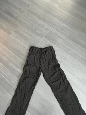 Svarta mjukisbyxor från H&M - Svarta mjukisbyxor från H&M med elastisk midja och avslappnad passform. Perfekta för chill dagar eller när du vill ha det bekvämt. Materialet är mjukt och lätt, och byxorna har en enkel, stilren look utan synliga detaljer.