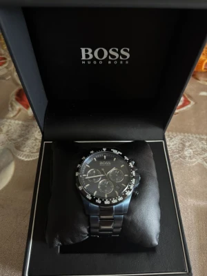 Blå Hugo Boss Hero Sport klocka - Köpte för 4 k ny, testade den 1 gång men köpte i en annan färg. Snygg och modern Hugo Boss Hero Sport 1513758 klocka med blå urtavla och matchande blå länkarmband i rostfritt stål. Klockan har kronograf, datumvisning och sportig design med tydliga index och detaljer i silver. 