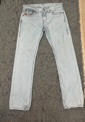 True Religion jeans - Vintage True Religion-jeans, ljusblå. Köpta från en vintagebutik, men passade inte. Straight modell. Storlek 32, men jag tror att det är mer som storlek 30-31. Liten fläck på insidan av låret. Innebärslängd 79-80cm, midjemått 42cm. 