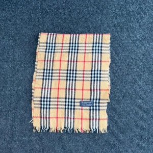 Burberry scarf  - Burberry-scarf som är 100% äkta. Mindre defekter kan förekomma enligt bild men inget märkvärdigt då de är vintage. Snabb leverans och trygg handel då vi har 7 års erfarenhet i branschen. Vid frågor eller bud, skicka gärna ett meddelande. 1014