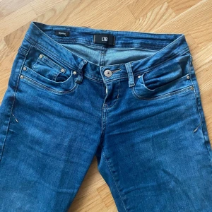 Blå bootcut jeans från LTB - Säljer ett par klassiska blå jeans från LTB i modellen Valerie. Jeansen har bootcut-ben, låg midja och fem fickor. Snygga kontrastsömmar och en cool tvätt ger dem en tidlös look. Perfekta till sneakers eller boots.